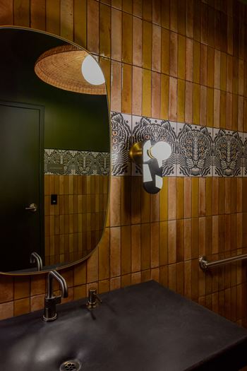 A bathroom with a black sink and a green door.